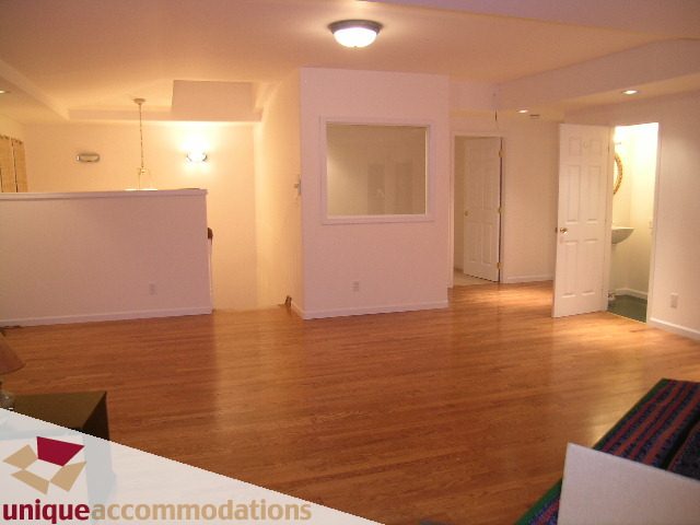 Bright living room with hardwood floors and a large mirror. - 1416 Chartwell Drive, West Vancouver