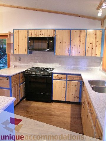 Bright kitchen with wooden cabinets, granite countertops, and hardwood floors. - 4655 Clovelly Walk, West Vancouver