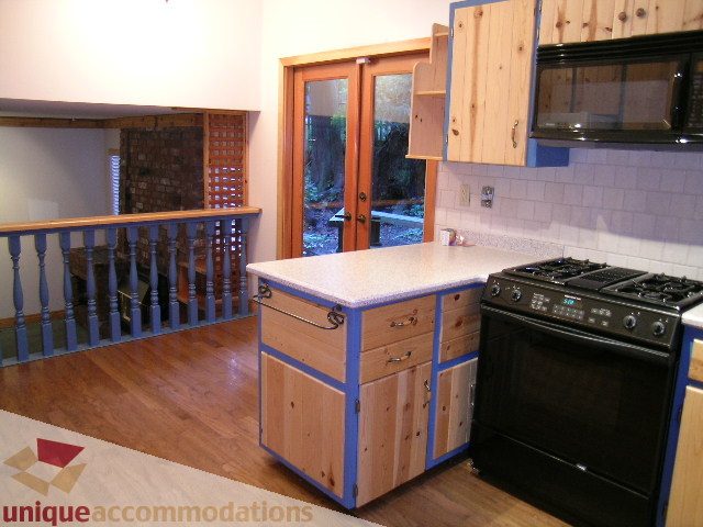 Bright kitchen with light wood cabinets, granite countertops, and hardwood floors. - 4655 Clovelly Walk, West Vancouver