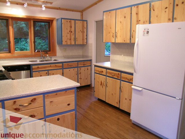 Bright kitchen with wooden cabinets, granite countertops, and hardwood floors. - 4655 Clovelly Walk, West Vancouver