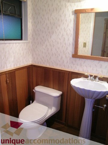 Furnished bathroom with wooden cabinets and a sink. - 4655 Clovelly Walk, West Vancouver