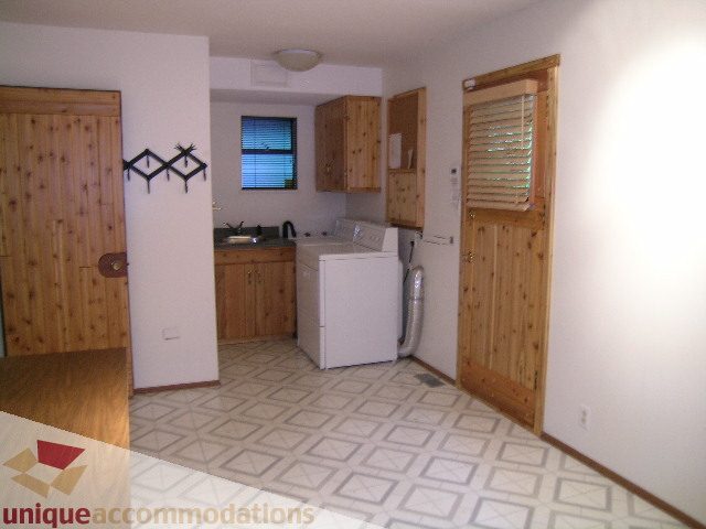Bright kitchen with wooden cabinets, white countertops, and patterned linoleum flooring. - 4655 Clovelly Walk, West Vancouver