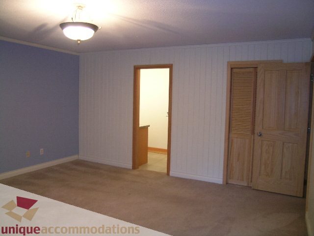Den area with carpeted floor and wooden doors leading to other rooms. - 4655 Clovelly Walk, West Vancouver