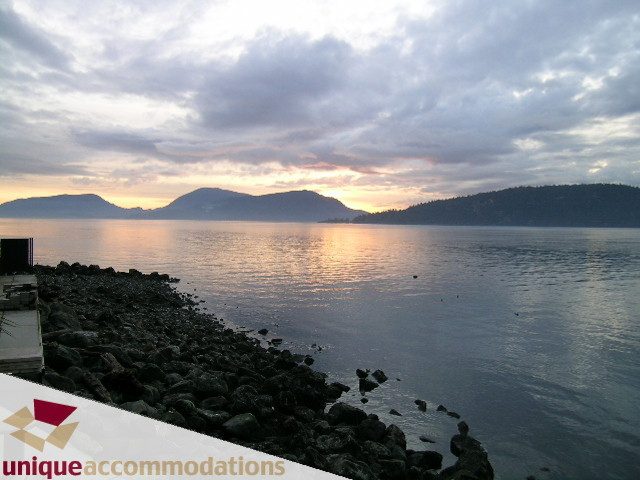 Oceanfront view with calm waters and distant hills at sunset. - 2 Strachan Point Road, West Vancouver