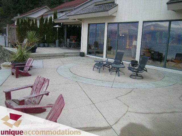 Furnished patio with outdoor seating and large glass doors leading to the house. - 2 Strachan Point Road, West Vancouver