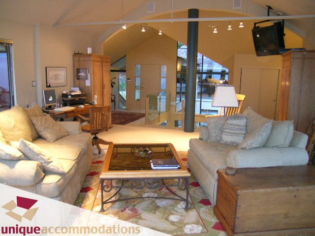 Furnished living room with cozy sofas, wooden coffee table, and large windows. - 2 Strachan Point Road, West Vancouver