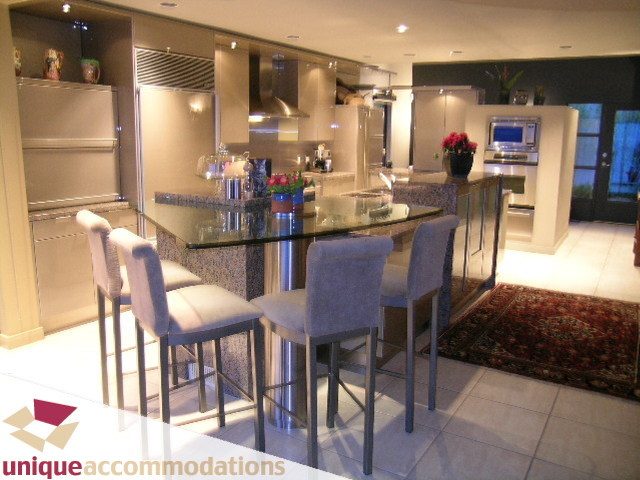Bright kitchen with granite countertops, stainless steel appliances, and a modern dining area. - 2 Strachan Point Road, West Vancouver