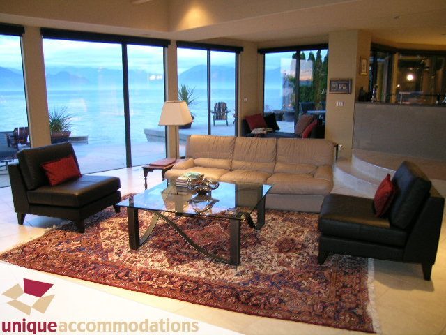 Spacious living room with large windows, ocean view, and plush furniture. - 2 Strachan Point Road, West Vancouver