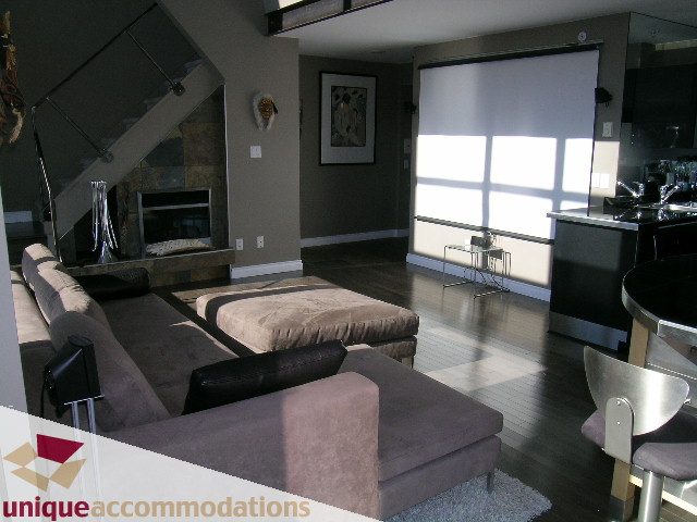 Bright living room with modern furniture, hardwood floors, and a city view. - 2001 - 1238 Richards Street, Vancouver Downtown
