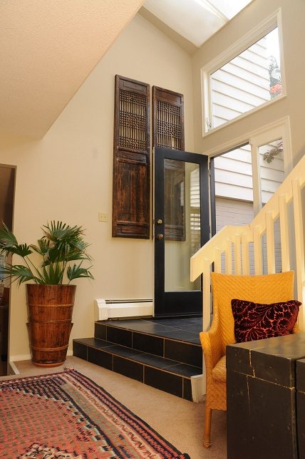 Foyer with wooden shutters, patterned rug, and potted plants. - Guest House - 440 Stevens Drive, West Vancouver
