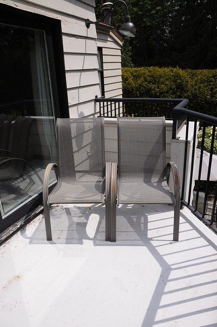 Furnished balcony with two chairs and black railing, sunny day. - Guest House - 440 Stevens Drive, West Vancouver