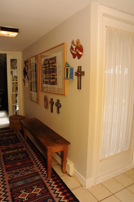 Foyer with framed artwork, wooden bench, and patterned rug. - Guest House - 440 Stevens Drive, West Vancouver