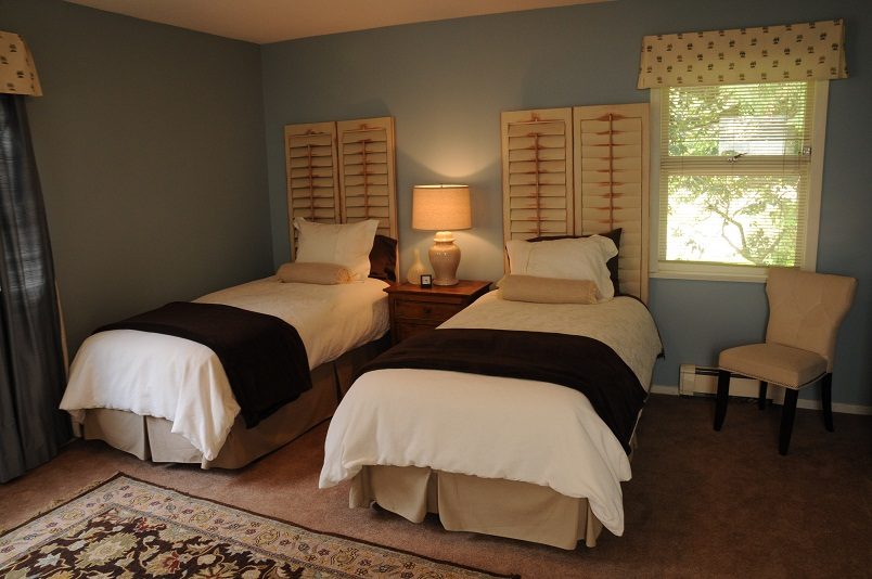 Bright twin bedroom with shutters, window view, and cozy bedding. - Guest House - 440 Stevens Drive, West Vancouver