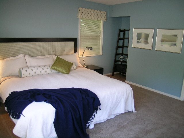 Spacious bedroom with blue walls, white bedding, and a cozy navy throw blanket. - Guest House - 440 Stevens Drive, West Vancouver