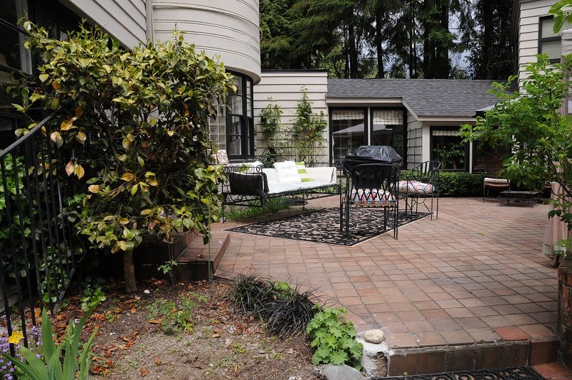 Furnished patio with brick flooring, outdoor seating, and greenery. - Guest House - 440 Stevens Drive, West Vancouver