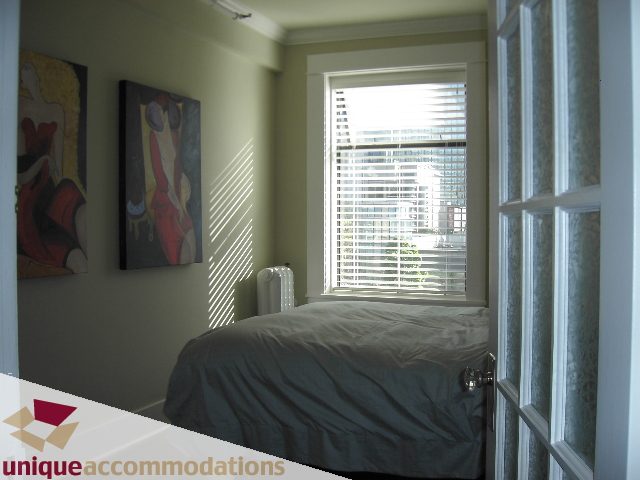 Bright bedroom with large window, artwork on walls, and neatly made bed. - 45 - 777 Burrard Street, Vancouver Downtown