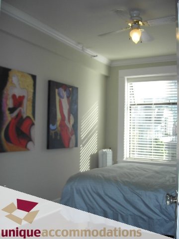 Furnished 1-bedroom bedroom with artwork on walls and ceiling fan. - 45 - 777 Burrard Street, Vancouver Downtown