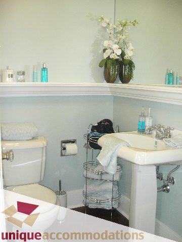 Furnished bathroom with white countertop, vase of orchids, and neatly arranged toiletries. - 45 - 777 Burrard Street, Vancouver Downtown