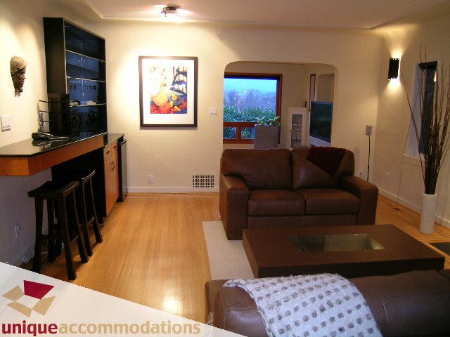 Spacious living room with hardwood floors, city view, and modern furnishings. - 3967 West Broadway, Vancouver West Side