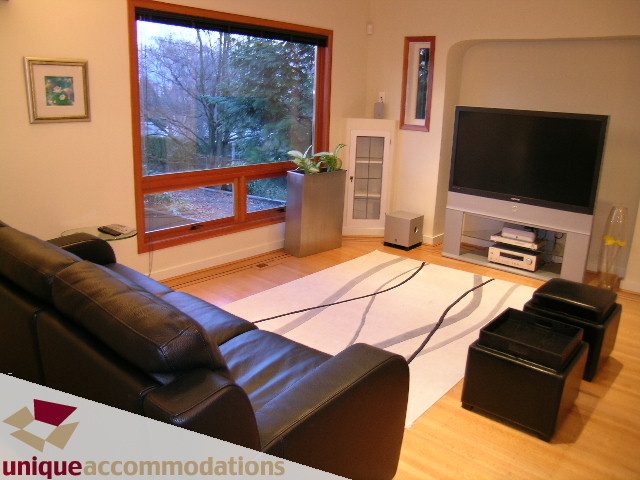 Bright living room with hardwood floors, large window, and modern furniture. - 3967 West Broadway, Vancouver West Side