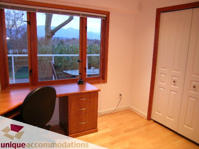 Bright study with wooden desk, hardwood floors, and city view. - 3967 West Broadway, Vancouver West Side