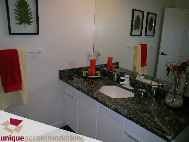 Furnished bathroom with granite countertops and red accents. - 3967 West Broadway, Vancouver West Side