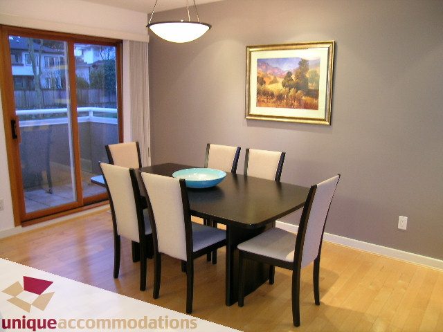 Dining room with hardwood floors, modern chairs, and a framed landscape painting. - 3967 West Broadway, Vancouver West Side