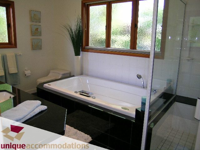 Spacious bathroom with black countertops, large window, and modern fixtures. - 3967 West Broadway, Vancouver West Side