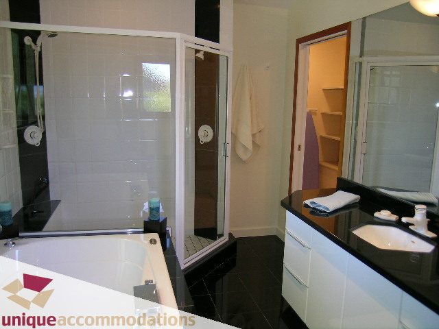 Modern bathroom with black countertops and white cabinets. - 3967 West Broadway, Vancouver West Side