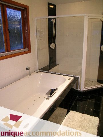 Modern bathroom with sleek white countertop and black tiled floor. - 3967 West Broadway, Vancouver West Side
