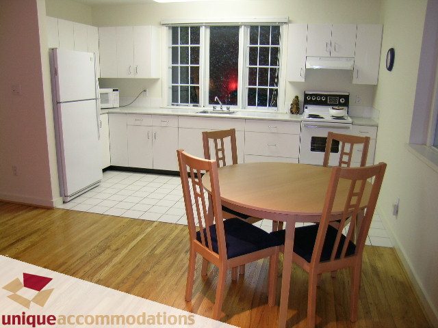 Bright kitchen with white cabinets, hardwood floors, and a view of the city. - 3967 West Broadway, Vancouver West Side
