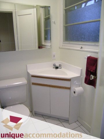 Bright bathroom with white countertop and tiled floor. - 3967 West Broadway, Vancouver West Side