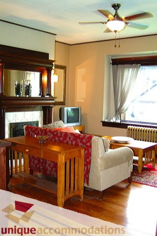 Furnished living room with wooden furniture, hardwood floors, and a fireplace. - 1 - 2812 Yukon, Vancouver West Side