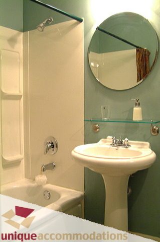 Bright bathroom with white sink, round mirror, and shower. - 1 - 2812 Yukon, Vancouver West Side