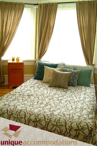Spacious bedroom with patterned bedding, hardwood floors, and large windows with curtains. - 1 - 2812 Yukon, Vancouver West Side