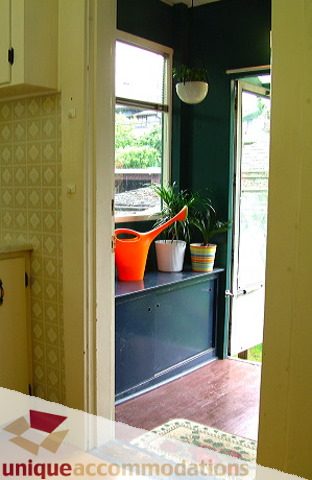 Bright kitchen with orange watering can on dark blue cabinet, light patterned wallpaper. - 1 - 2812 Yukon, Vancouver West Side