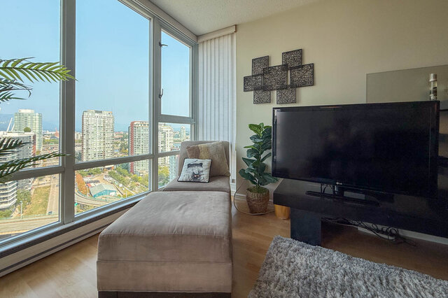 Spacious living room with city view, large windows, and modern decor. - 2602 - 1033 Marinaside Crescent, Vancouver Downtown