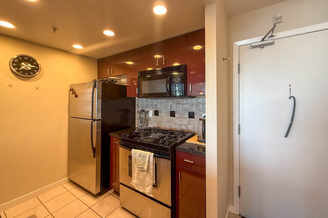 Compact kitchen with granite countertops, stainless steel appliances, and a gas stove. - 2602 - 1033 Marinaside Crescent, Vancouver Downtown
