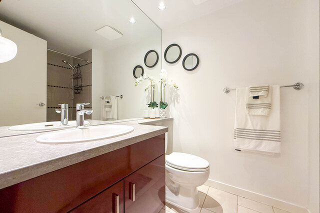 Spacious bathroom with dual sinks, dark wood vanity, and modern decor. - 2602 - 1033 Marinaside Crescent, Vancouver Downtown