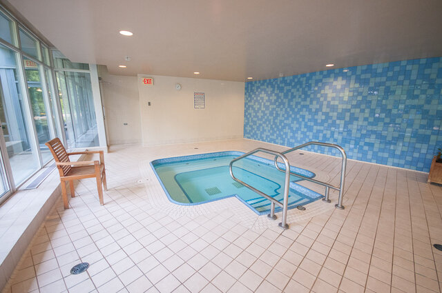 Spacious, well-lit indoor pool area with tiled walls and floor, perfect for relaxation. - 2602 - 1033 Marinaside Crescent, Vancouver Downtown
