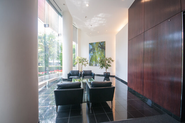 Spacious living room with modern furniture, large windows, and a city view. - 2602 - 1033 Marinaside Crescent, Vancouver Downtown