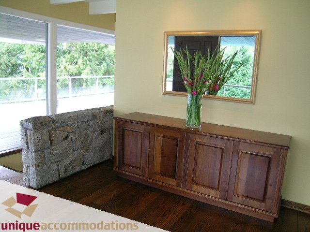 Furnished living room with stone bench, wooden cabinets, and hardwood floors. - 6189 Nelson Avenue, West Vancouver
