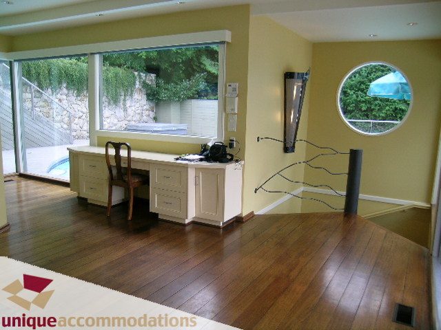 Bright kitchen with hardwood floors, large windows, and a round window, showcasing a serene outdoor view. - 6189 Nelson Avenue, West Vancouver
