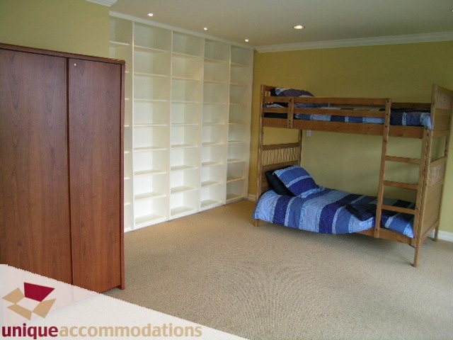 Furnished 5-bedroom house with wooden bunk beds and built-in shelving. - 6189 Nelson Avenue, West Vancouver