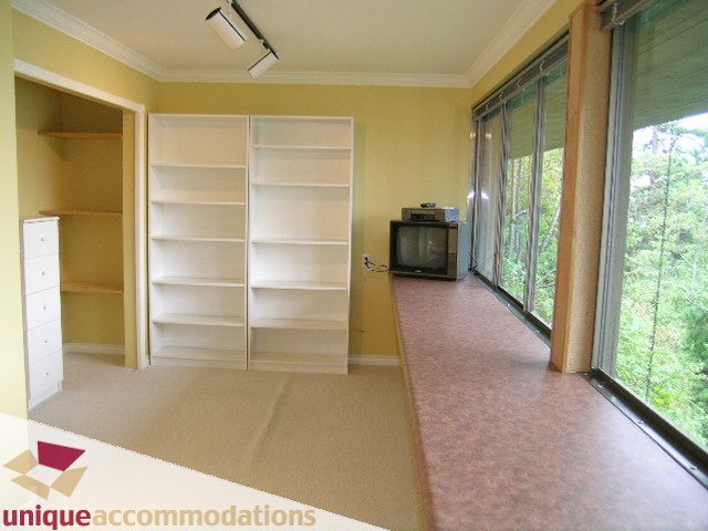 Bright living room with built-in shelves, hardwood floors, and a city view. - 6189 Nelson Avenue, West Vancouver