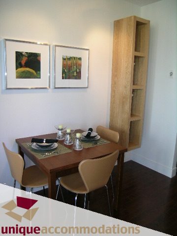 Furnished dining area with wooden shelves, framed artwork, and hardwood floors. - 302 - 1228 West Hastings Street, Vancouver Downtown