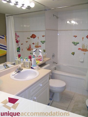 Bright bathroom with white countertops and colorful fish decals on the wall. - 314 - 855 W. 16th Street, North Vancouver