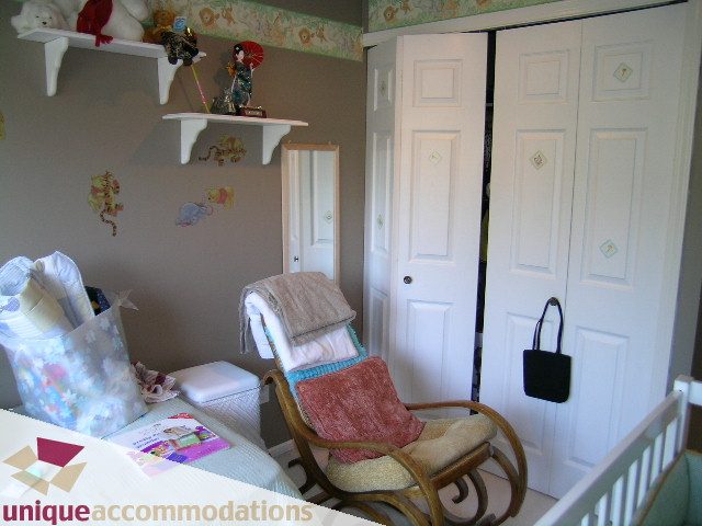 Bright nursery with rocking chair, crib, and shelves. - 314 - 855 W. 16th Street, North Vancouver