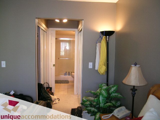 Furnished living room with a lamp, plant, and view of the bathroom. - 314 - 855 W. 16th Street, North Vancouver
