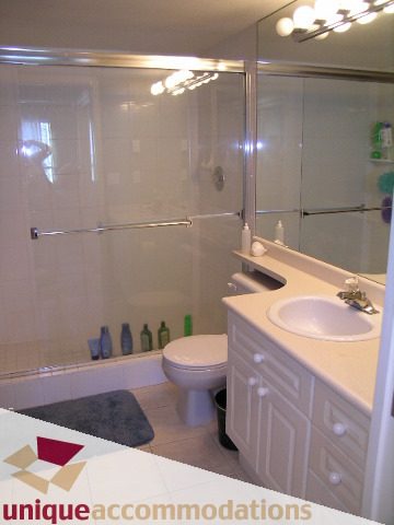 Bright bathroom with white countertops and a glass shower, clean and well-maintained. - 314 - 855 W. 16th Street, North Vancouver